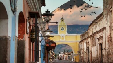 colorful historical buildings in Antigua Guatemala with volcano in the background