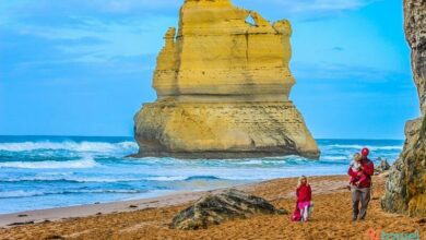 people walking on the beach with views of one of the 12 apostles