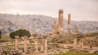 crumbling columns of Temple of Hercules Citadel with the hills of amman covered in buildings in the background