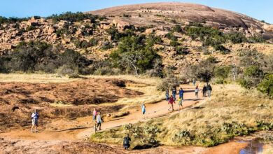hikers on trail with view of Enchanted Rock