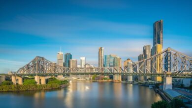 bridge crossing river wtih Brisbane skyline behind it
