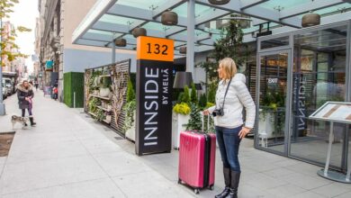 woman holding a suitcase outside a hotel